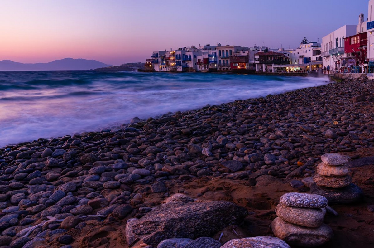 Mykonos beach at sunset with Little Venice in background