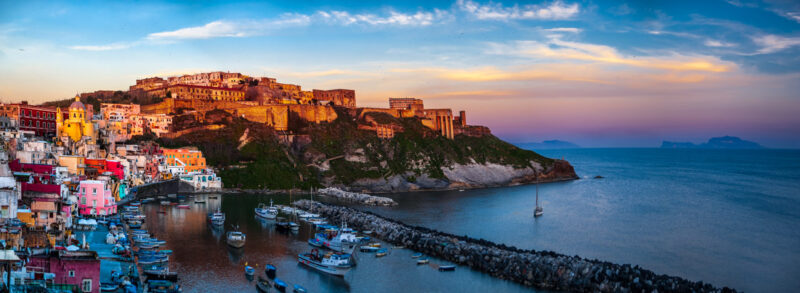 Procida al tramonto con vista su Marina della Corricella e Terra Murata